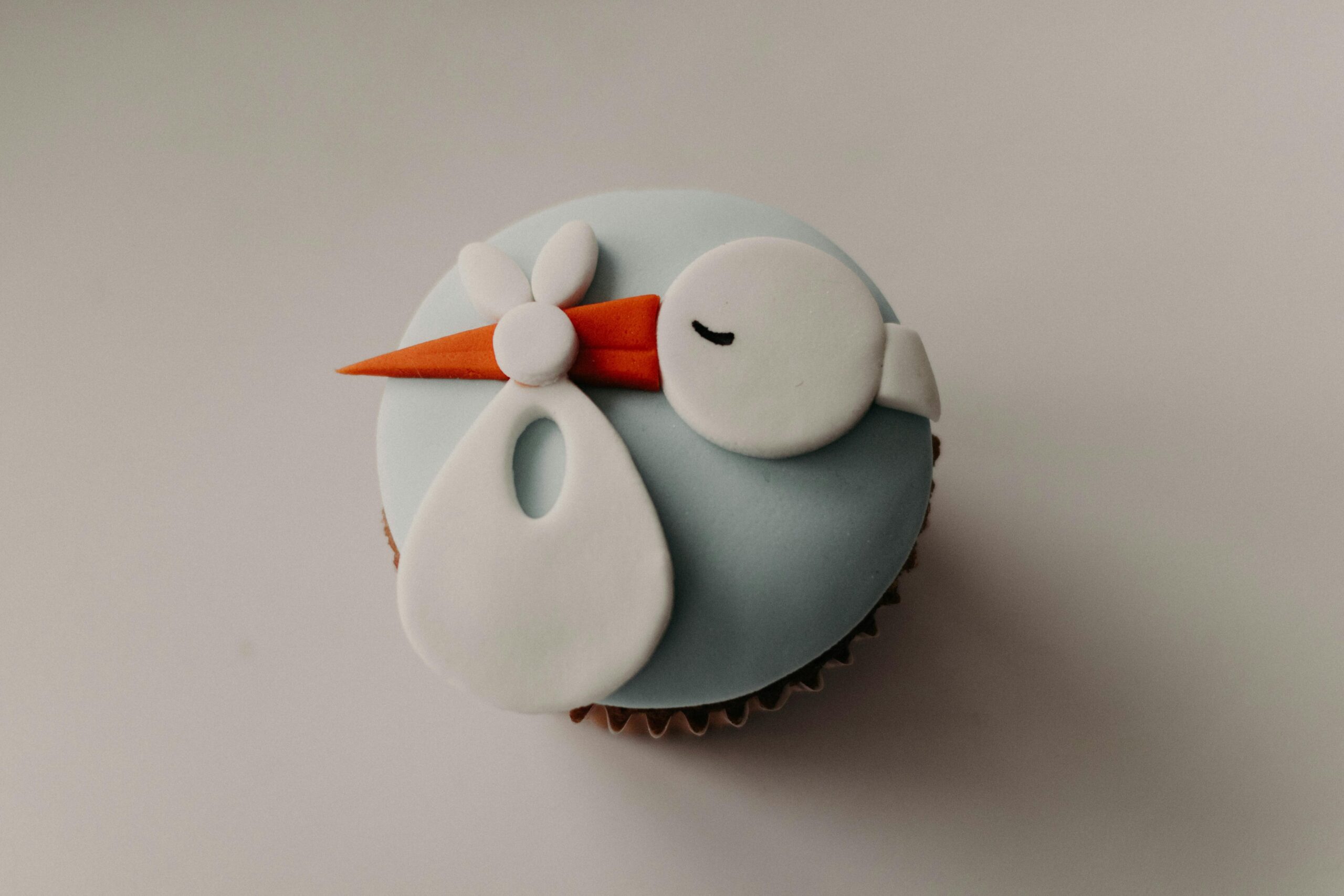 A charming cupcake decorated with a stork design, perfect for baby showers and celebrations.